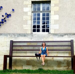 Irma en miniatura sentada en un banco de gigante de jardín.